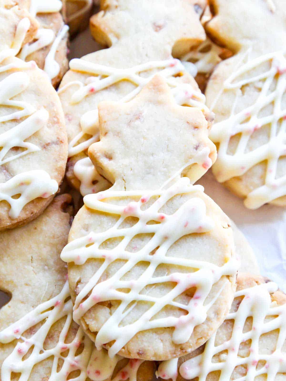 Close up of a Christmas shortbread cookie drizzled with peppermint icing.