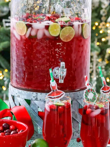 A big glass beverage container filled with holiday Christmas Punch.