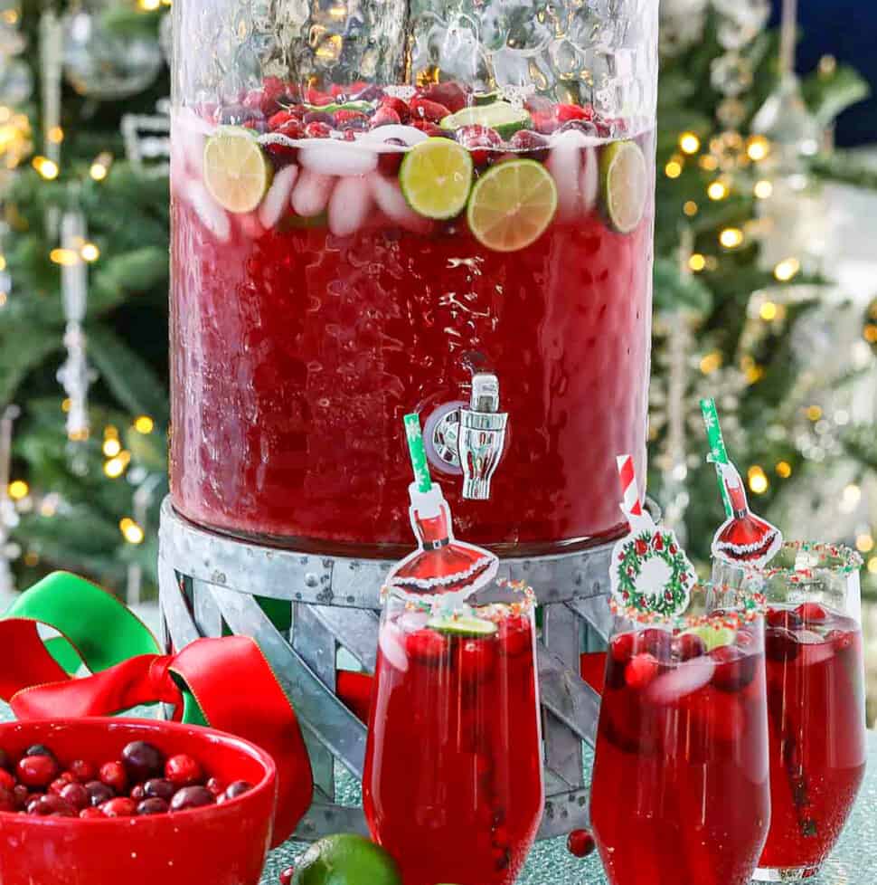 A big glass beverage container filled with holiday Christmas Punch.