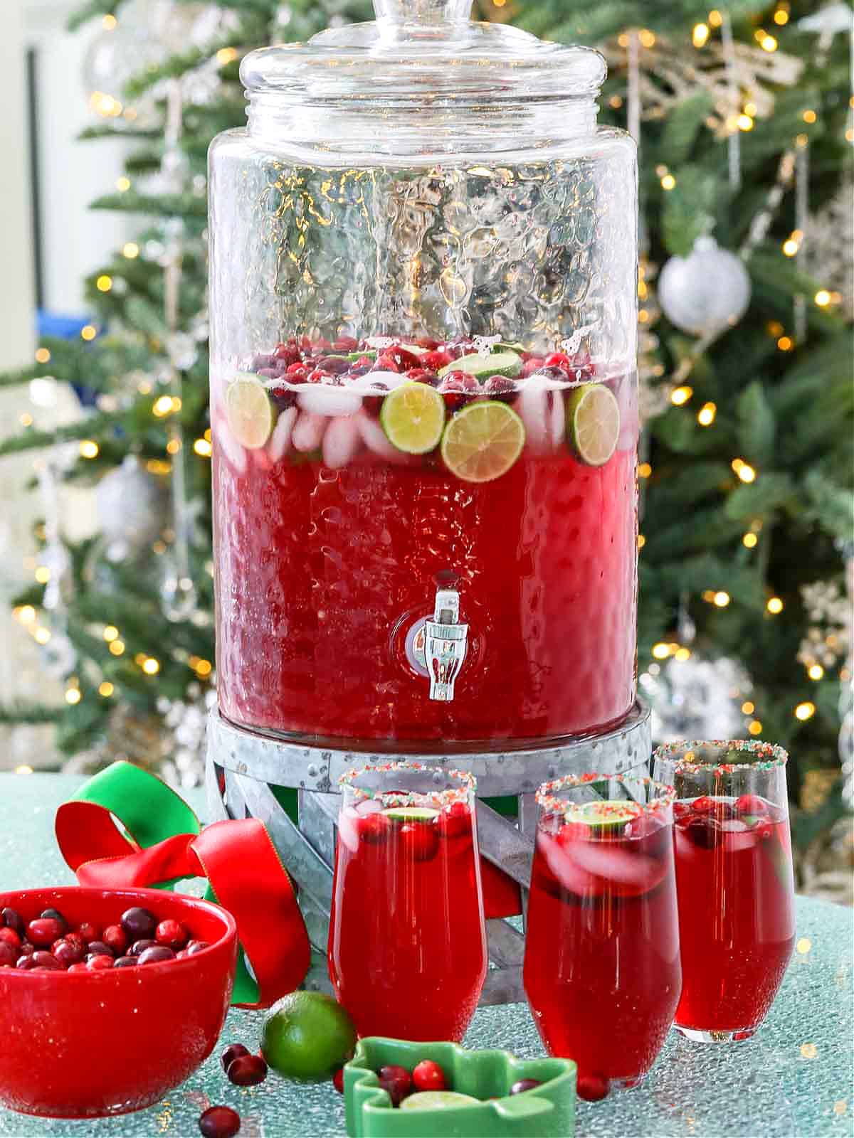 A big glass beverage container filled with holiday Christmas Punch.