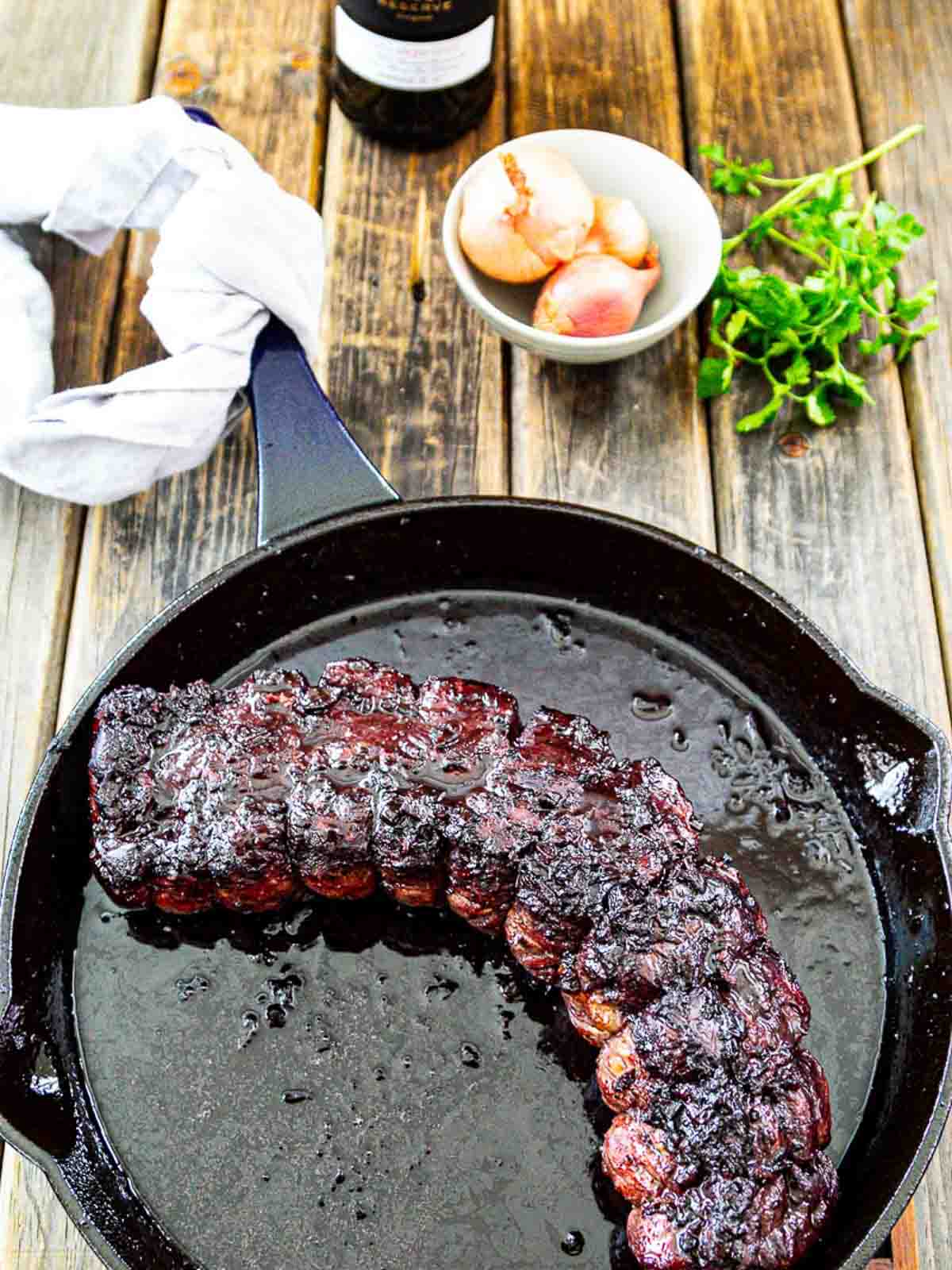 Overhead view of a cast iron pan with a seared beef roast (roast beef) cooked to the right temperature.