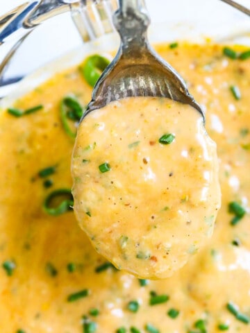 A vintage spoon scooping up remoulade sauce to use on a recipe.