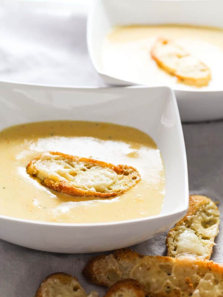 A large cheese crouton on a bowl of cheese soup.