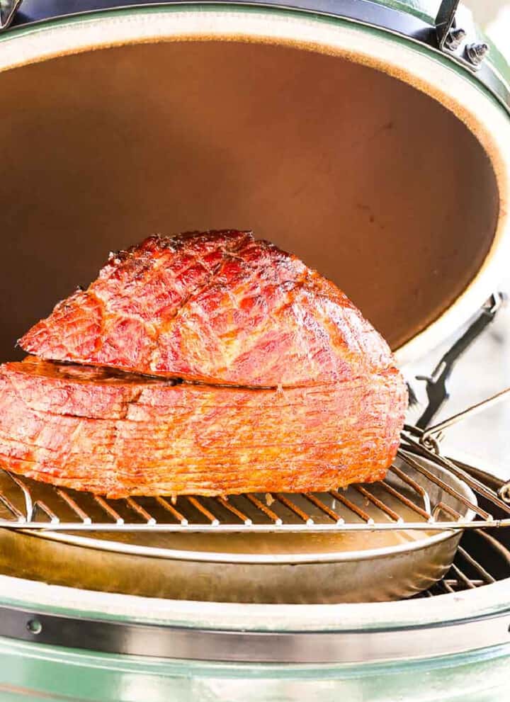 A double smoked ham on a outdoor smoker ready to eat.