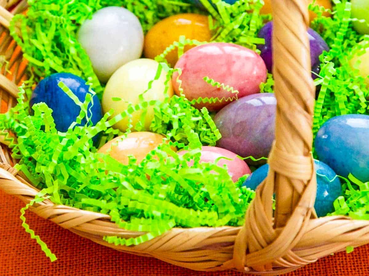 A vintage Easter basket filled with bright color eggs for one of the best Easter dinner ideas.