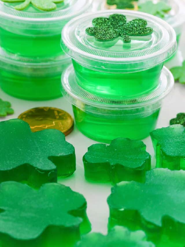 A white rectangle platter with green jello shots and jigglers shaped like shamrocks.