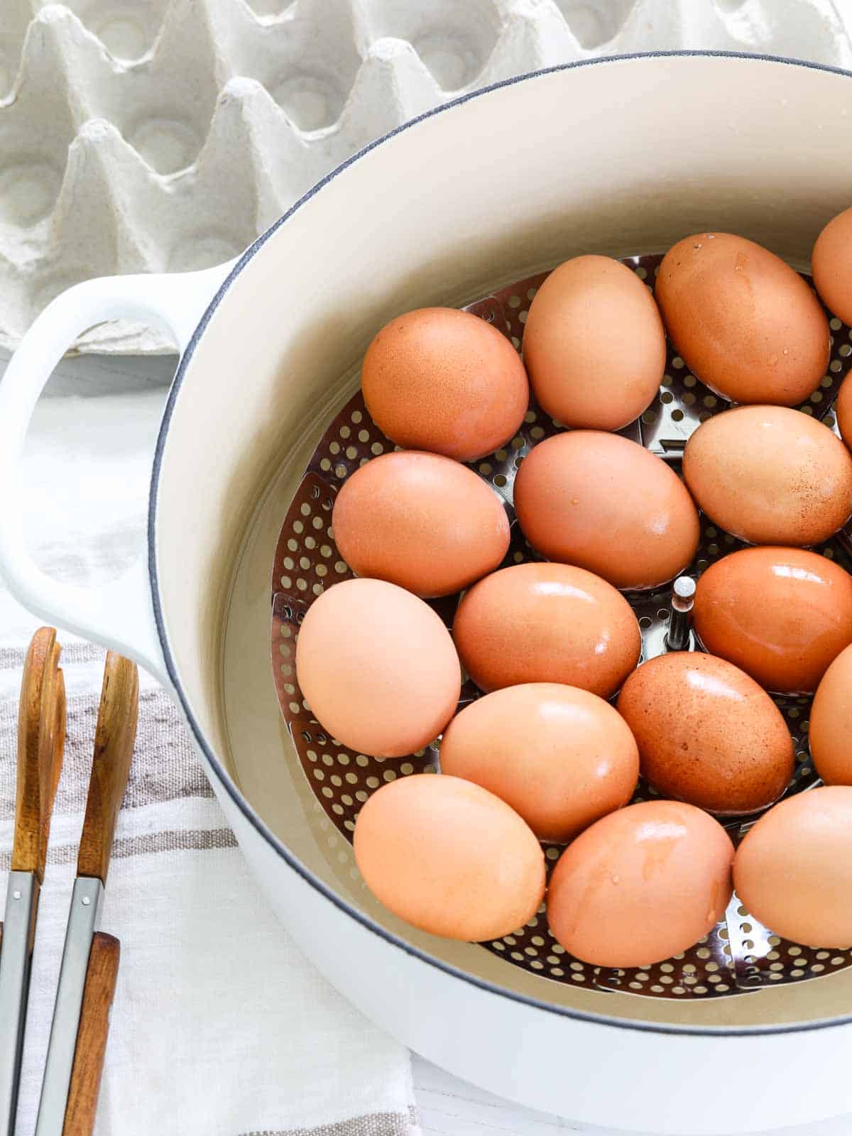 Brown eggs with drops of moisture in a pot that were just cooked for hard boiled eggs.