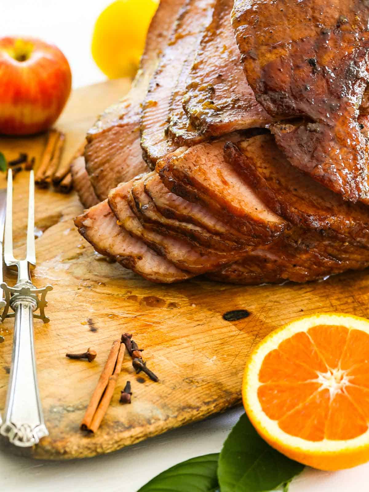 A big juicy slices ham on a cutting board ready to eat.