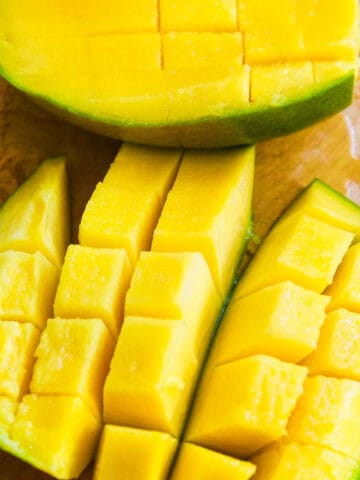 A perfectly cut open mango with cubes cut into the fruit.