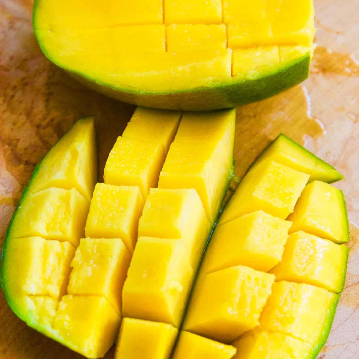 A perfectly cut open mango with cubes cut into the fruit.