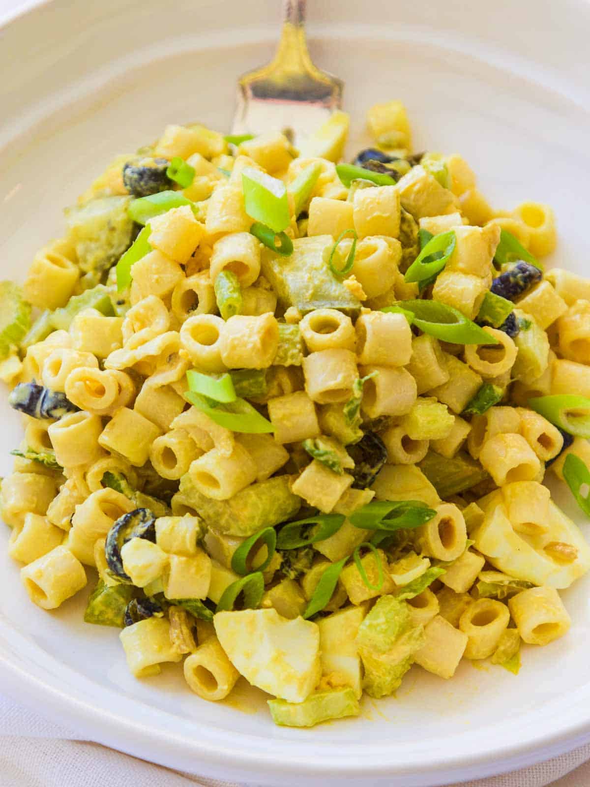 White plate piled with homemade classic macaroni salad.