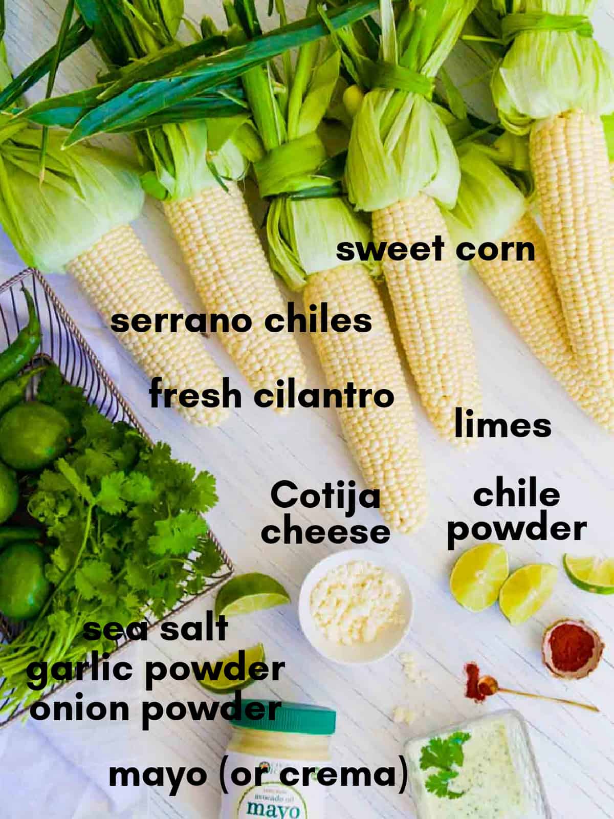 All the ingredients for authentic elotes Mexican street corn on a table all labeled.