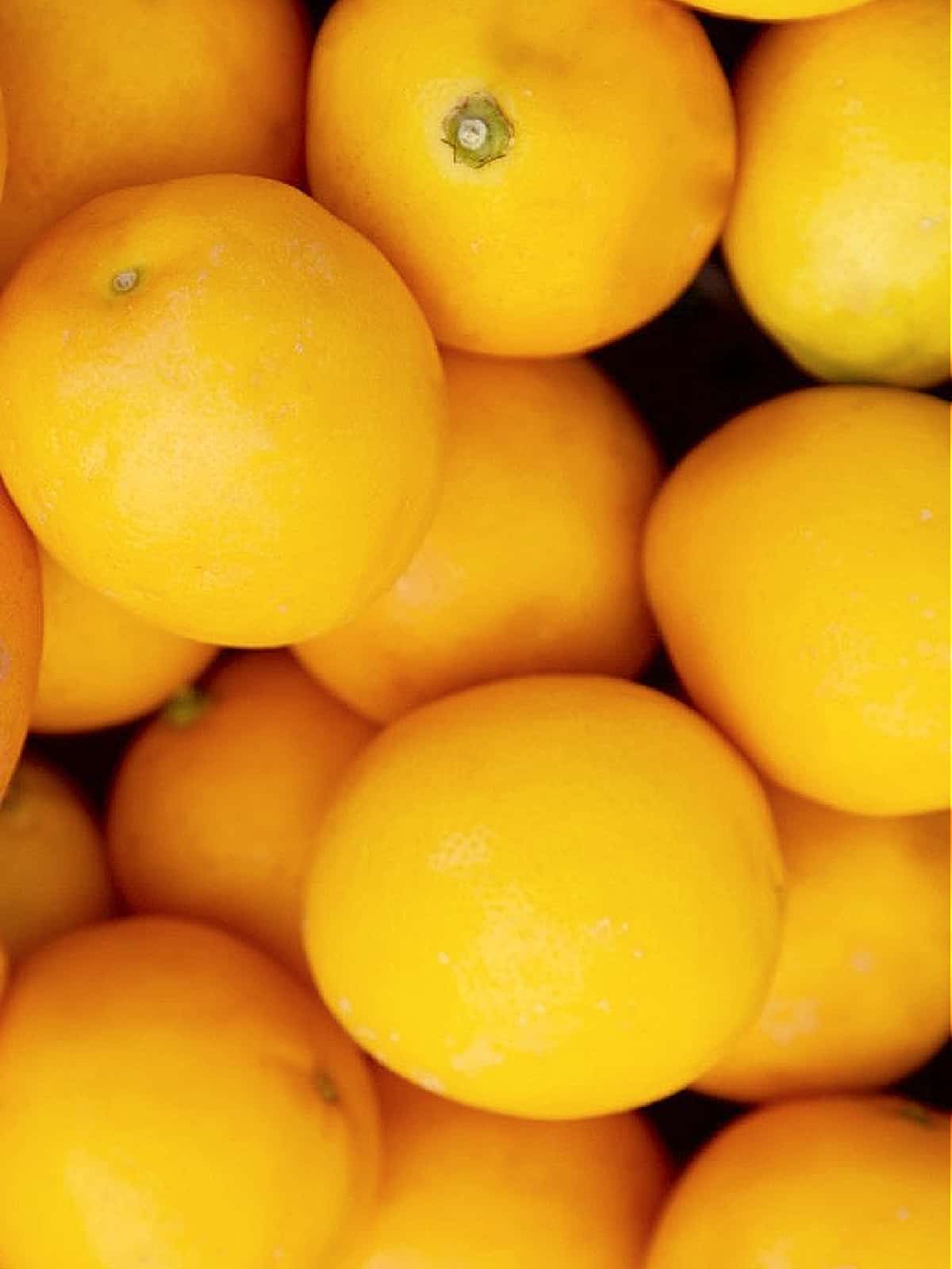 A pile of bright yellow lemons in a pile ready to make lemon recipes.