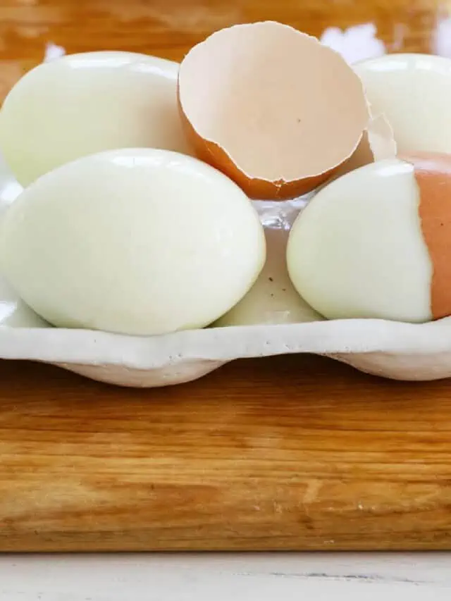 6 perfectly hard boiled eggs with a cracked half of an egg shelf on top.