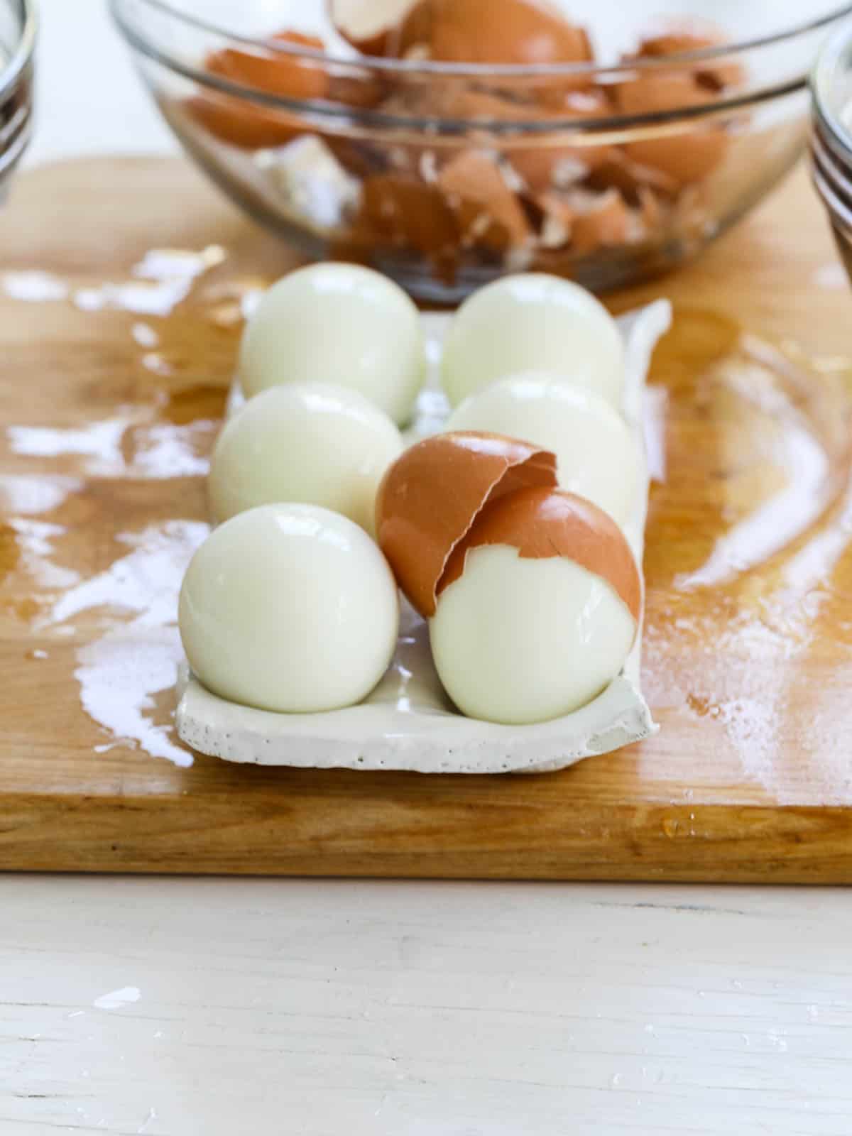 A white ceramic egg holder filled with freshly steamed hard boiled eggs.