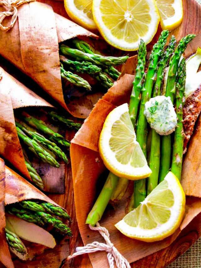 A wooden platter with cedar wrapped salmon, asparagus, and lemon butter.