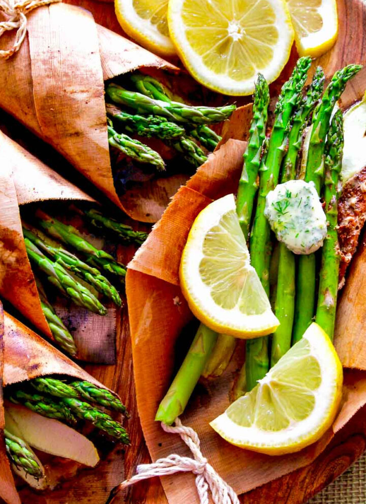 A wooden platter with cedar wrapped salmon, asparagus, and lemon butter.