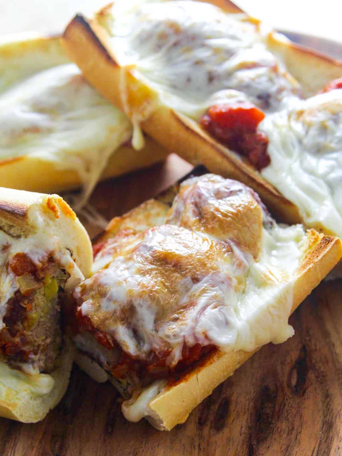 A hot meatball sub sandwich with marinara sauce and melted golden brown cheese.