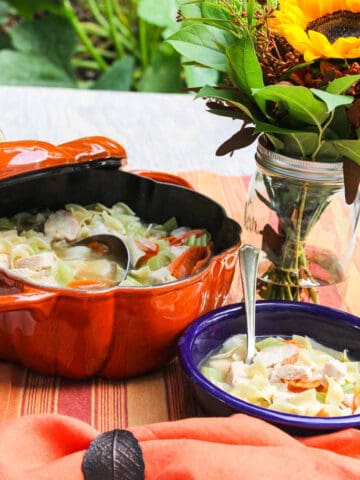 A blue bowl filled with homemade chicken noodle soup.