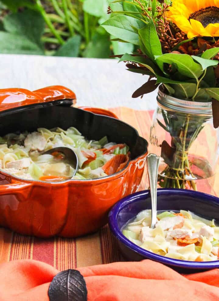 A blue bowl filled with homemade chicken noodle soup.