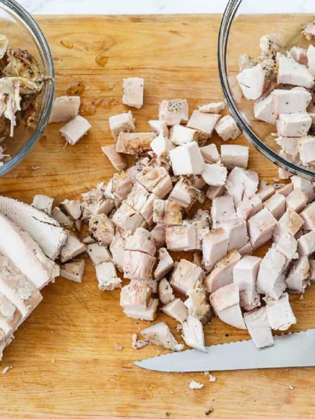 Cutting boneless chicken breasts into diced cubes of meat to use in recipes.