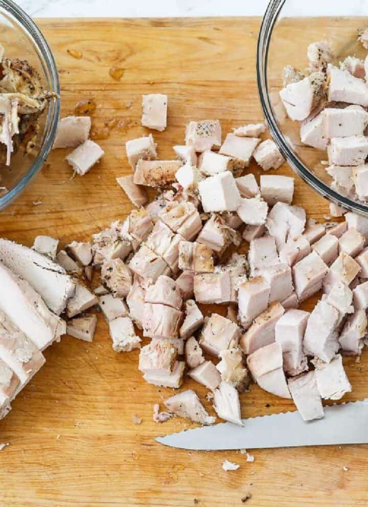 Cutting boneless chicken breasts into diced cubes of meat to use in recipes.