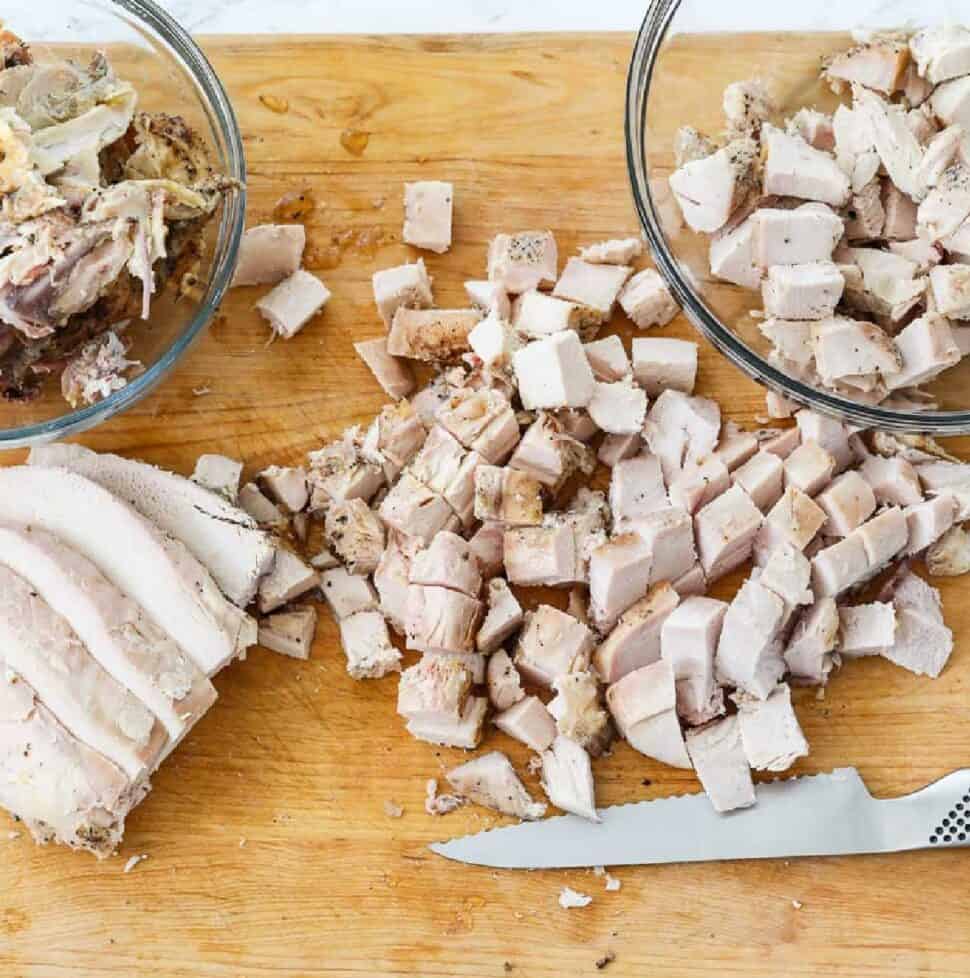 Cutting boneless chicken breasts into diced cubes of meat to use in recipes.