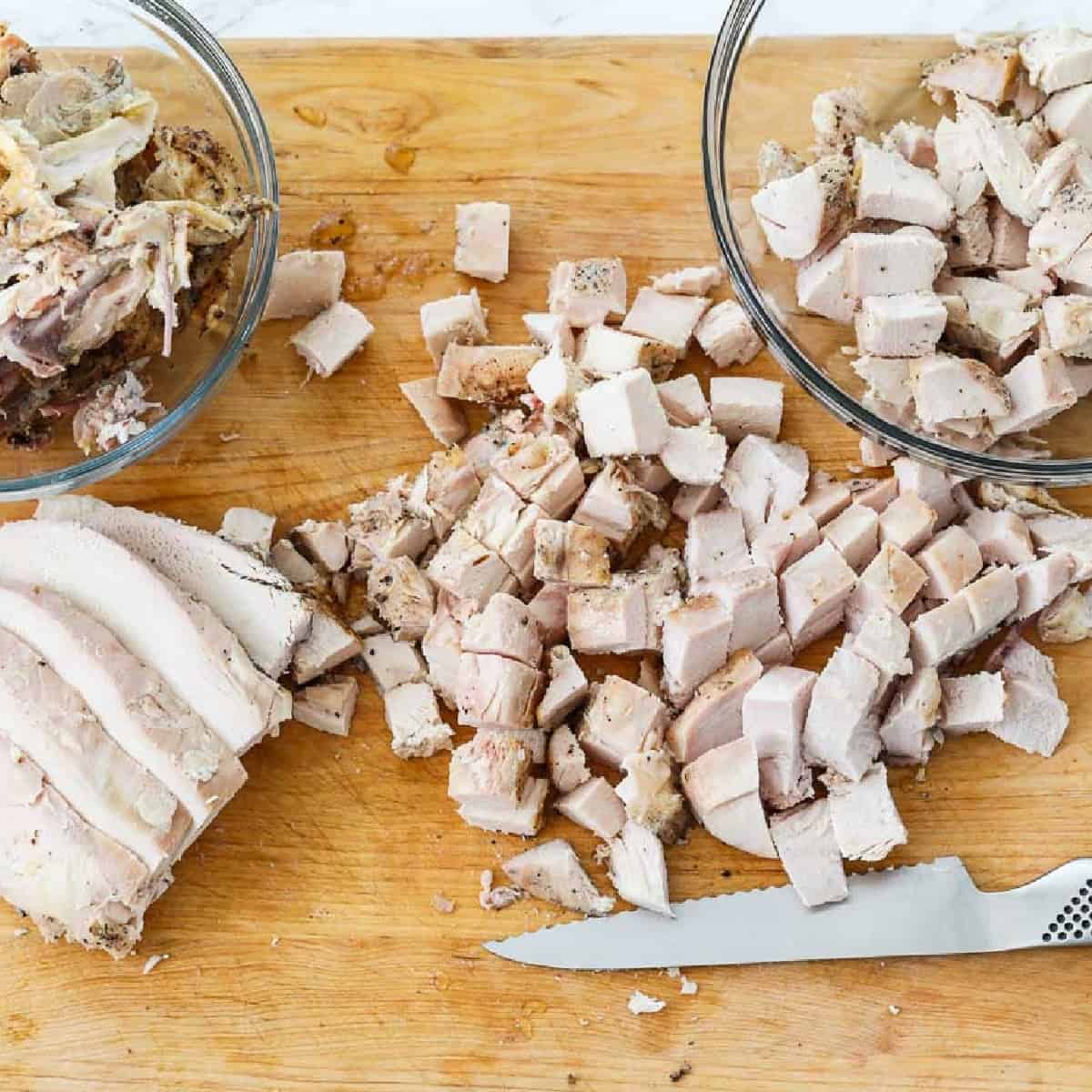 Cutting boneless chicken breasts into diced cubes of meat to use in recipes.