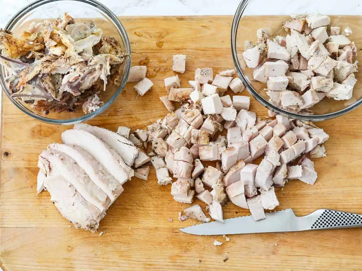 Cutting boneless chicken breasts into diced cubes of meat to use in recipes.