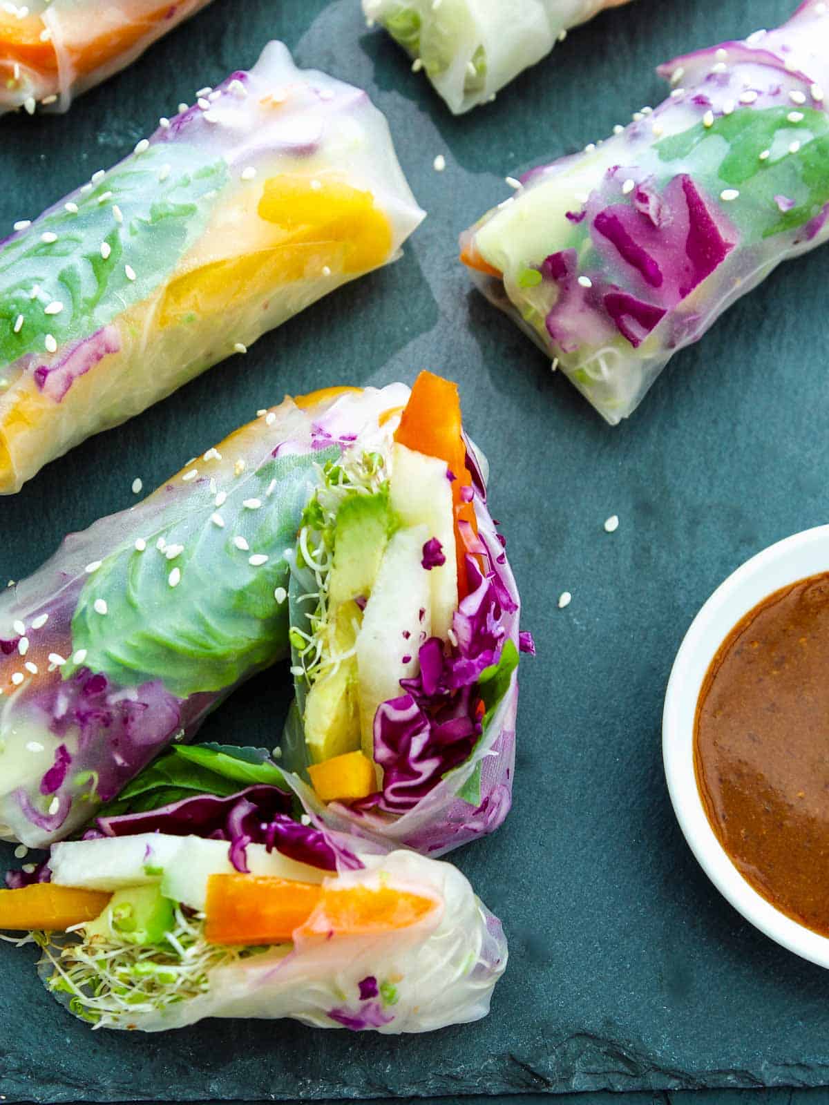 https://www.delicioustable.com/wp-content/uploads/2022/05/Spring-rolls-sliced-open-with-ginger-dipping-sauce.jpg