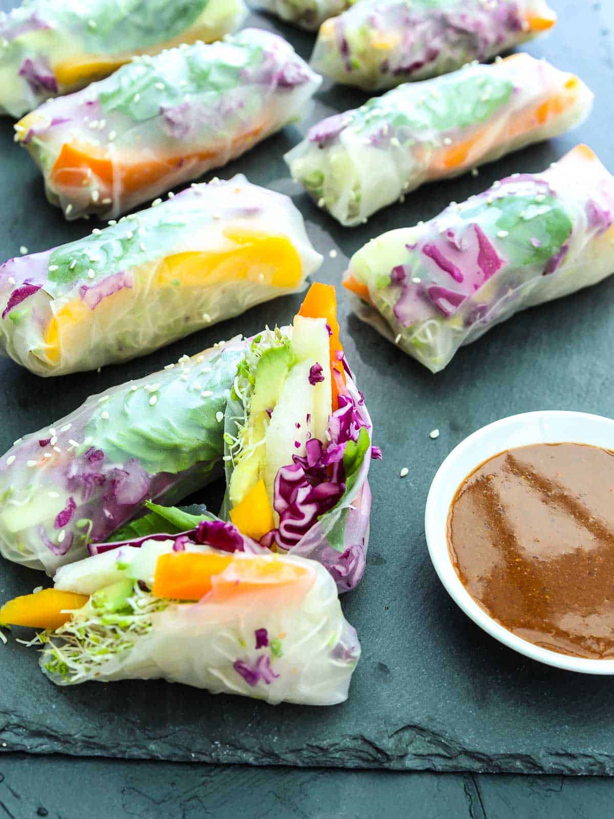 A sliced open spring roll made with rice paper wrapper stuffed with colorful veggies.