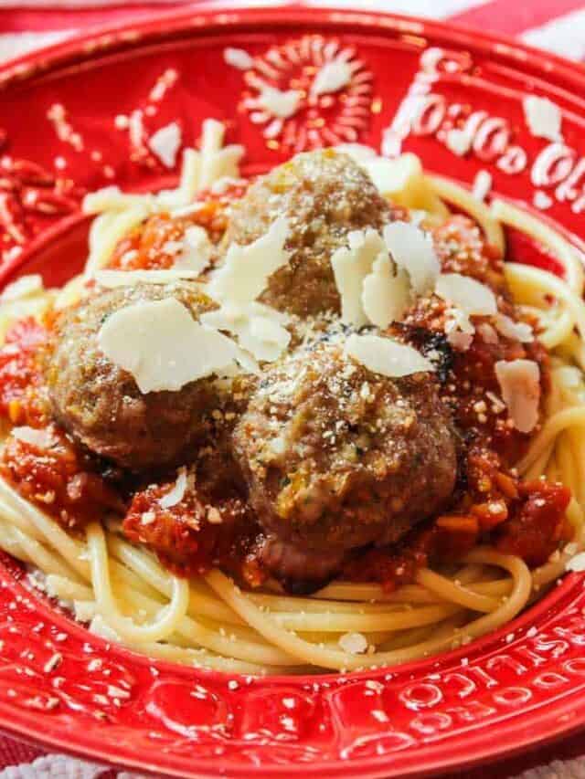 A large red bowl filled with hot pasta, homemade turkey meatballs, and sauce.