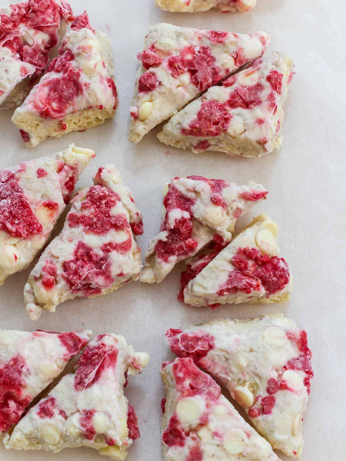 Frozen raspberry scones dough cut and studded with white chocolate chips and sweet red raspberries.