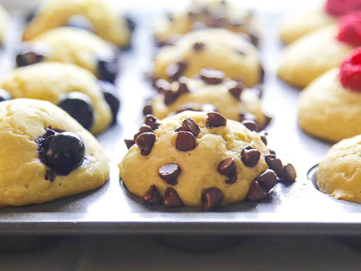 Close up of a baked pancake muffins with mini chocolate chips in a muffin baking tin.