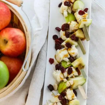 A white platter filled with apple brie skewers for Thanksgiving appetizers.