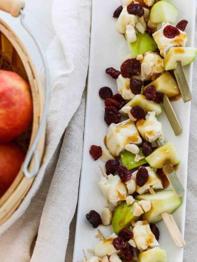 A white platter filled with apple brie skewers for Thanksgiving appetizers.