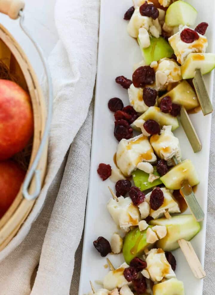 A white platter filled with apple brie skewers for Thanksgiving appetizers.