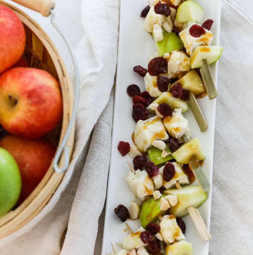 A white platter filled with apple brie skewers for Thanksgiving appetizers.