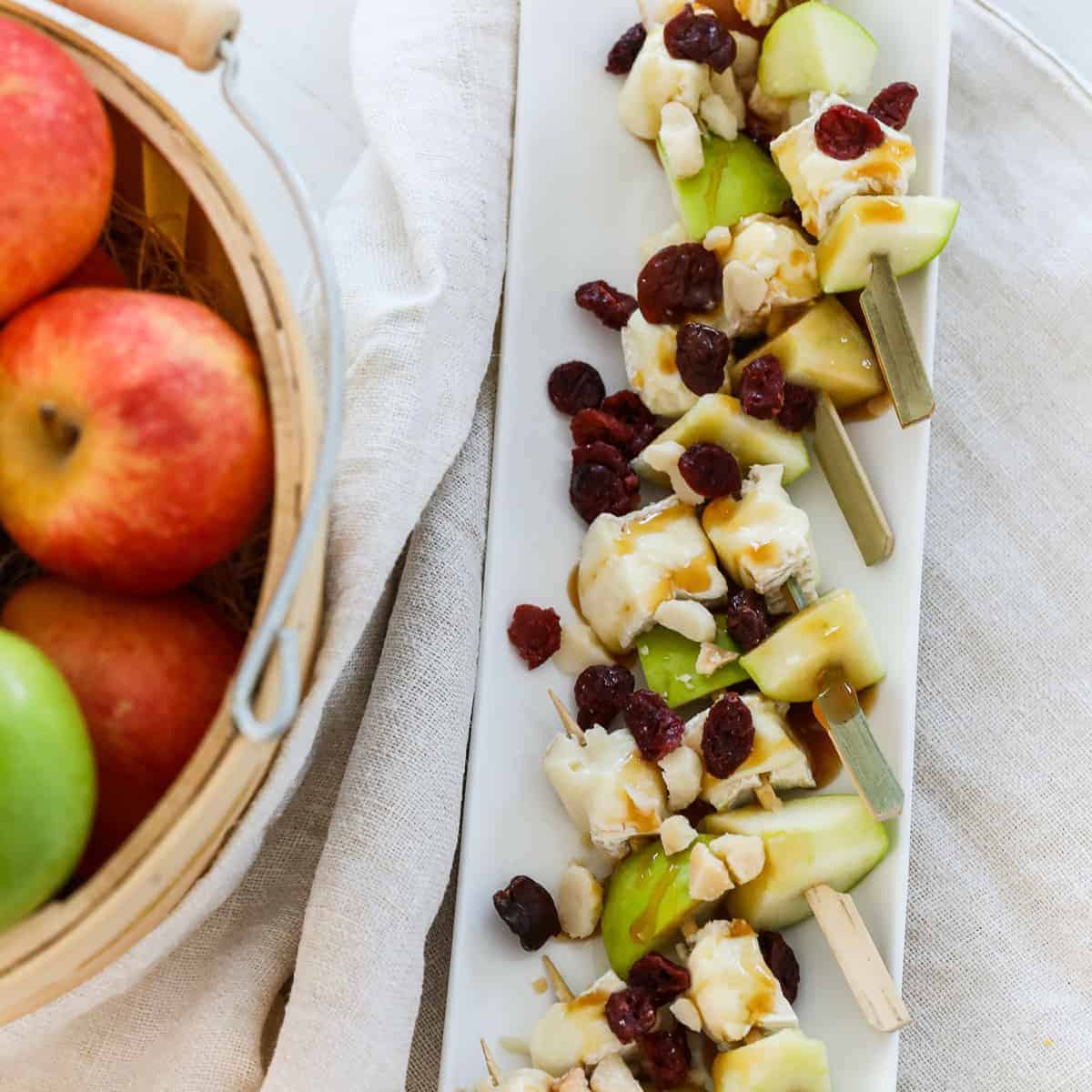 A white platter filled with apple brie skewers for Thanksgiving appetizers.