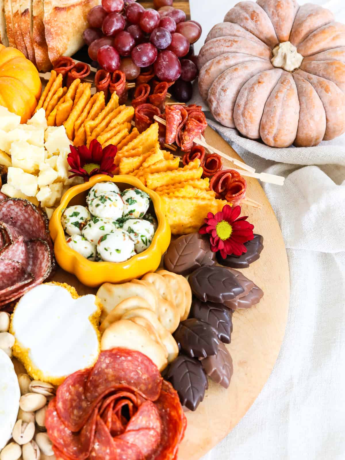 A Thanksgiving cheeseboard filled with gorgeous sliced meats, cheeses, and snacks for a party.