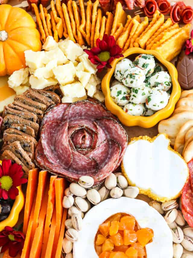 A bountiful Thanksgiving charcuterie cheeseboard fill with colorful meats, cheeses nuts and more for Thanksgiving.