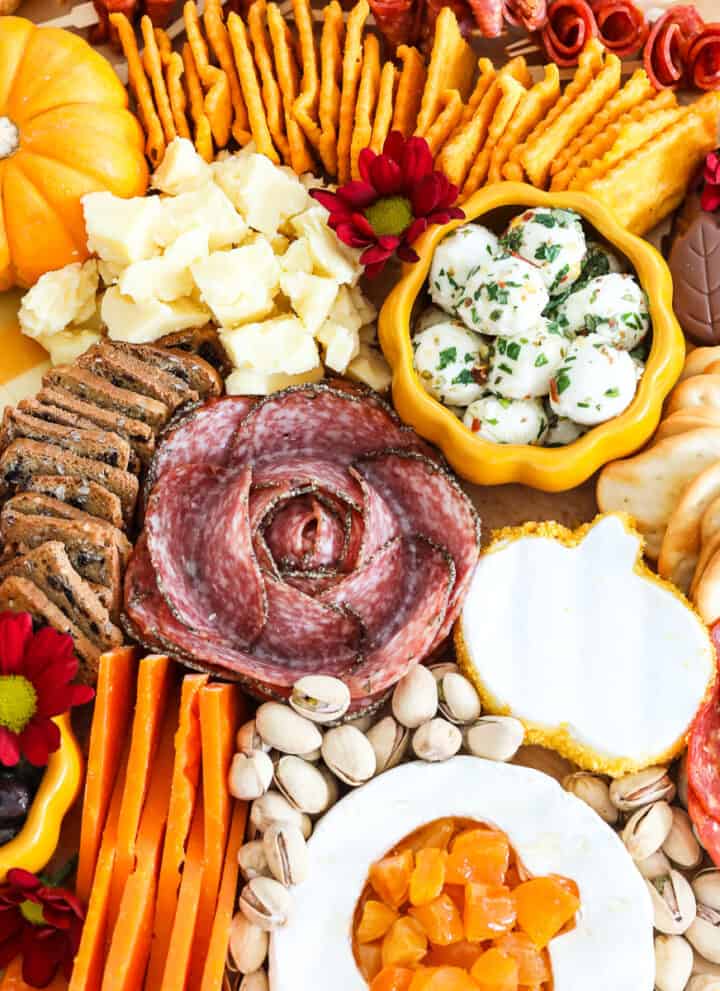 A bountiful Thanksgiving charcuterie cheeseboard fill with colorful meats, cheeses nuts and more for Thanksgiving.