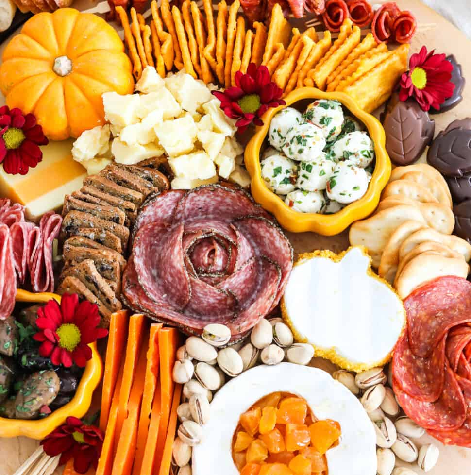 A bountiful Thanksgiving charcuterie cheeseboard fill with colorful meats, cheeses nuts and more for Thanksgiving.