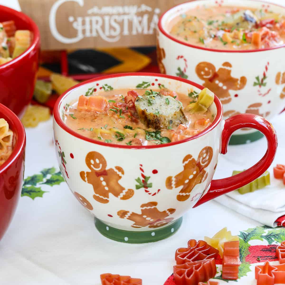 A cheerful red handled holiday mug with gingerbread filled with Christmas soup.