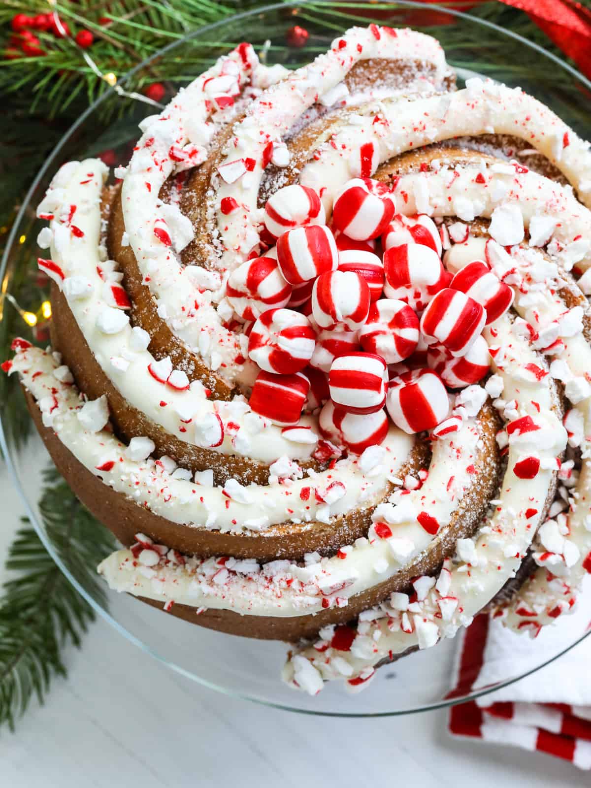 A gorgeous Christmas cake decorated with large piping of peppermint buttercream frosting and crushed and whole candy cane peppermints.