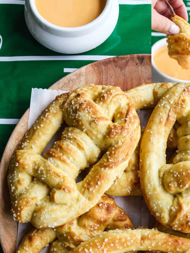 A wood platter loaded with soft pretzels shaped like footballs and beer cheese dip in a bowl nearby.