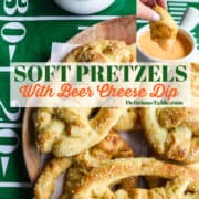 A wood platter loaded with soft pretzels shaped like footballs and beer cheese dip in a bowl nearby and a lady dipping a piece of pretzel into the cheesy dip.