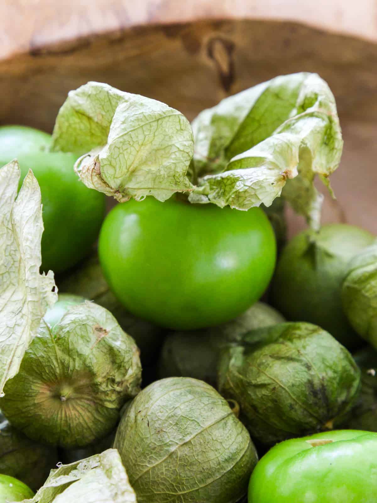 Close up view of green tomatillos for use in a recipe, some still have their paper husks on them, to be used in a Mexican food recipe.