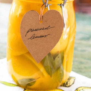 A large clamp jar of Preserved Lemons with a brown craft paper tag that says Preserved Lemons.