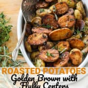 An oval white dish filled with golden brown baby potato halves ready to eat for dinner.